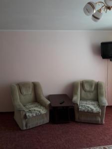 2 sillas y una mesa en una habitación en Апартаменты в центре en Cherkasy