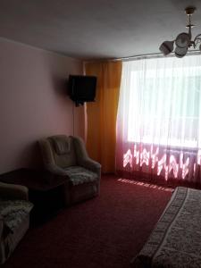 uma sala de estar com uma cadeira e uma janela em Апартаменты в центре em Cherkasy