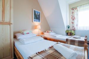 two twin beds in a room with a window at Pokoje Gościnne Góraleczka in Szaflary