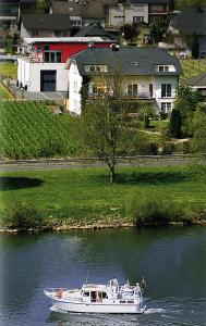 a white boat on the water in a river at Weingut Bernd Hermes in Kröv