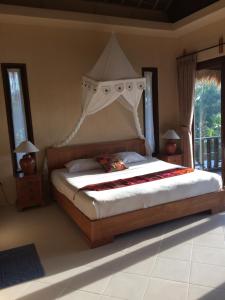 a bedroom with a large bed with a canopy at Lombok Villas, Villa PaoPao in Labuhanpoh +53 photos