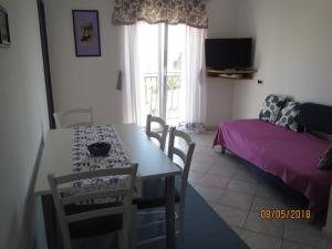 a living room with a table and chairs and a couch at Apartments Jann in Krk