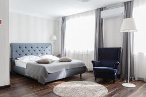 a bedroom with a blue bed and a blue chair at Park Hotel in Tolyatti