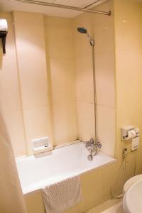 a bathroom with a shower with a sink and a toilet at Grand Inn Hotel in Bangkok