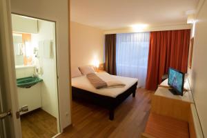 a bedroom with a bed and a desk at Ibis Graz in Graz