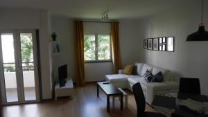 een woonkamer met een bank en een tafel bij Jasmineiro - Palms Palace Apartment in Funchal