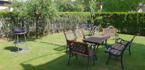 three chairs and a table and a grill in a yard at Apartment Milena in Maribor