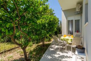 d'une terrasse avec une table et des chaises sous un arbre. dans l'établissement Allegria, à Kaštela