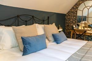 1 dormitorio con 1 cama con almohadas azules y blancas en Bull Inn en Reading