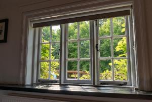 una ventana en una habitación con vistas a los árboles en Bull Inn, en Reading