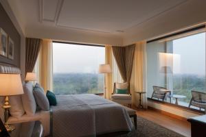 a hotel room with a large bed and a large window at The Oberoi New Delhi in New Delhi