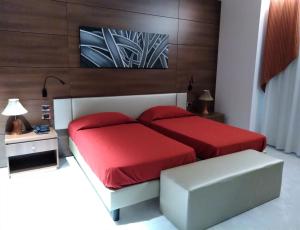 1 dormitorio con 2 camas con sábanas rojas en Family Center Hotel, en Polla