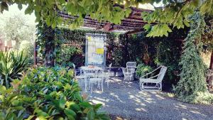 a patio with a table and chairs in a garden at Salvia e Rosmarino - Affittacamere in Liguria in Villanova dʼAlbenga