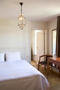 a bedroom with a bed and a table and a chandelier at Oranje City Hotel in Diest