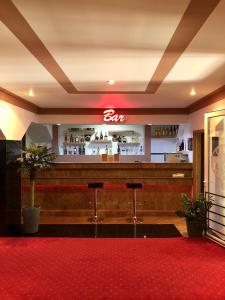 a bar in a restaurant with a red carpet at Hotel Rion in Mangalia