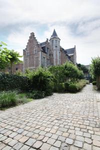 a stone driveway in front of an old building at Oranje City Hotel in Diest
