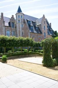 a large building with a garden in front of it at Oranje City Hotel in Diest