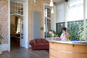 a woman talking on a cell phone in a room at Oranje City Hotel in Diest