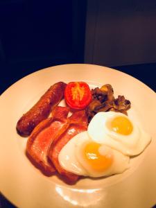 a plate of breakfast food with eggs sausage and bacon at Eslington Villa in Gateshead