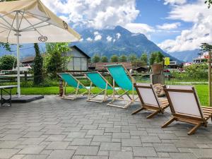 eine Reihe von Stühlen und einem Sonnenschirm auf einer Terrasse in der Unterkunft RiverLodge TCS Training & Freizeit AG in Interlaken