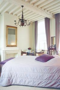 a bedroom with a bed and a chandelier at Oranje City Hotel in Diest
