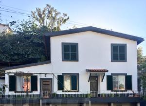a white house with black windows and a fence at Rochinha Cozy Home in Funchal