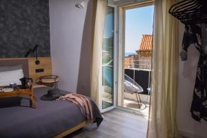 a bedroom with a bed and a view of a balcony at Close&Cosy in Dubrovnik