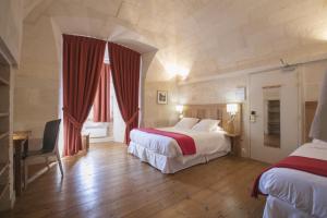 a hotel room with two beds and a desk at Les Chambres de l'Abbaye in Saintes +44 photos