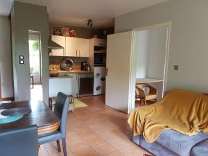 eine Küche und ein Wohnzimmer mit einem Sofa und einem Tisch in der Unterkunft À la Petite Maison in Gap