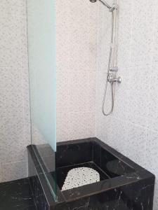 a bathroom with a shower with a black marble tub at Apartament de lux Mamaia Nord in Mamaia