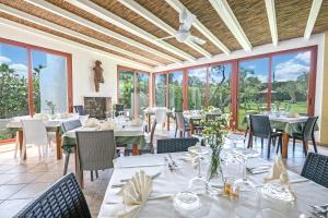 a dining room with tables and chairs and windows at Residence Contrada Schite in Presicce