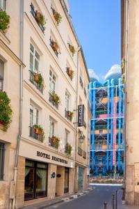 a blue and white building with a clock on the side of it at Hôtel Beaubourg in Paris