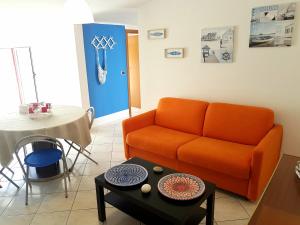- un salon avec un canapé orange et une table dans l'établissement Appartementi di Lu, à Marina di San Lorenzo