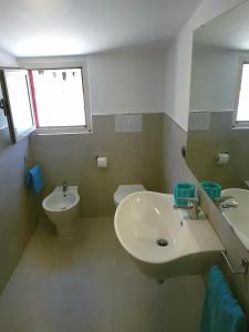 La salle de bains est pourvue d'un lavabo et de toilettes. dans l'établissement Appartementi di Lu, à Marina di San Lorenzo