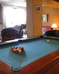 a pool table in a living room with afits at Hôtel Le Valaurie in Saint-Nazaire