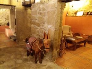 a brown donkey standing next to a stone wall at Carpe Diem in Navaridas