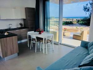 メンフィにあるVilla Ammariのテーブルのあるリビングルームと眺めの良いキッチン