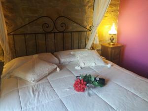 a white bed with a bunch of flowers on it at Carpe Diem in Navaridas
