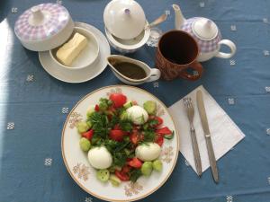 una mesa azul con un plato de comida con verduras en Guest House Deda Lali, en Kutaisi