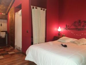 a bedroom with a white bed and red walls at Carpe Diem in Navaridas