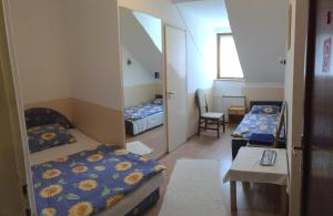 een kleine kamer met 2 bedden en een tafel bij Termál Vendégház in Veresegyház