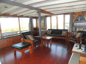 uma sala de estar com cadeiras, mesas e janelas em PS Federal Retreat Paddle Steamer Goolwa em Goolwa