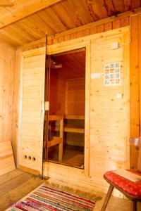 a wooden cabin with a sauna with a red stool at Ferienhaus Unterbrunnhaus in Finkenberg