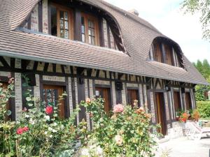 una casa con un techo con flores delante en En Bord de Seine, en Duclair