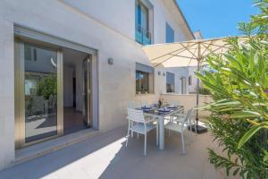 a patio with a table and chairs and an umbrella at Formentera 2 in Can Picafort