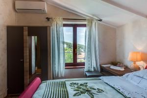 a bedroom with a bed and a window and a desk at Star in Mali Lošinj