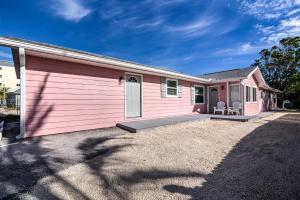a pink house with a large driveway at Serenity By The Sea Cottage A in Clearwater Beach