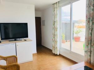 マラガにあるAtico Armengual Suite Málagaのリビングルーム(テレビ、大きな窓付)