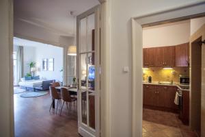 a kitchen and living room with a table and chairs at Sunny top floor balcony apartment near downtown in Budapest