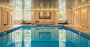 a large pool in a room with windows at Wyndham Trenython Manor in Fowey